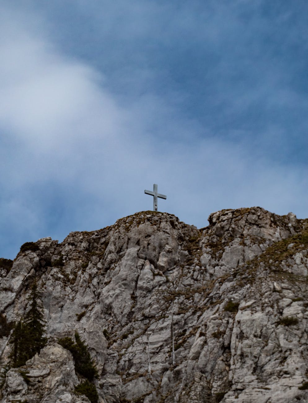 low angle shot of a cross atop a mountain